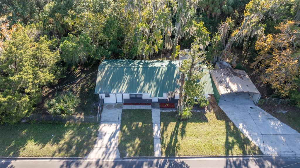 An aerial view shows a single-story house with a green metal roof and a carport — 1915 BRONSON STREET, PALATKA, FL