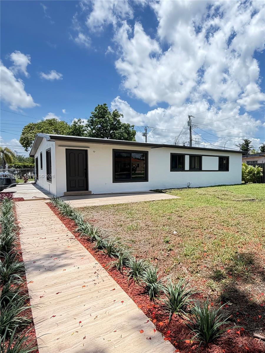 A single-story white house with dark trim features a wooden deck and a walkway — 2930 SW 106th Ave, Miami FL 33165, MIAMI, FL