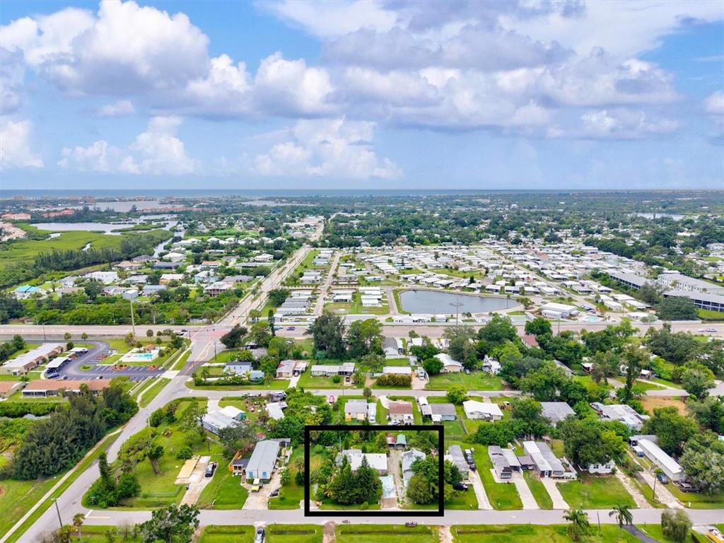 An aerial view shows a single-story house with a metal roof surrounded by trees — 507 PINEWOOD AVENUE, NOKOMIS, FL