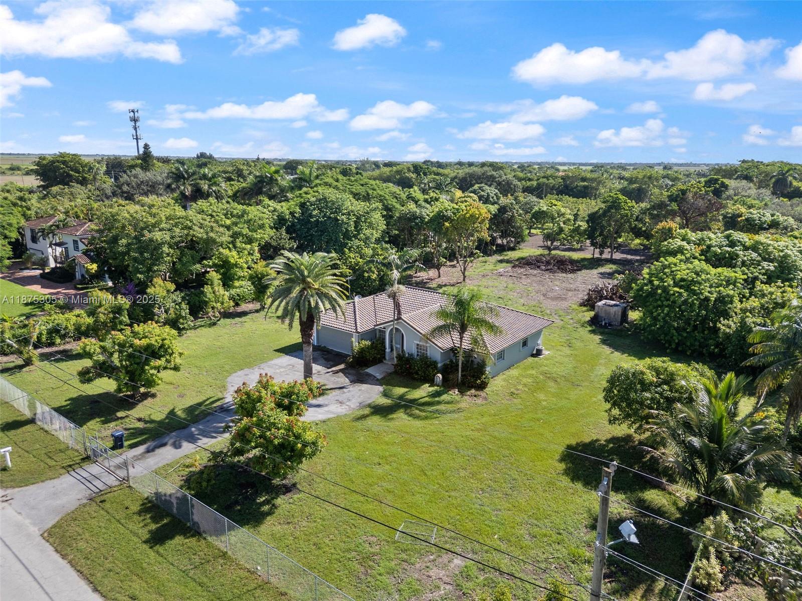 An aerial view shows a single-story house with a tile roof surrounded by lush trees — 16035 SW 173rd Ave, Miami FL 33187, MIAMI, FL