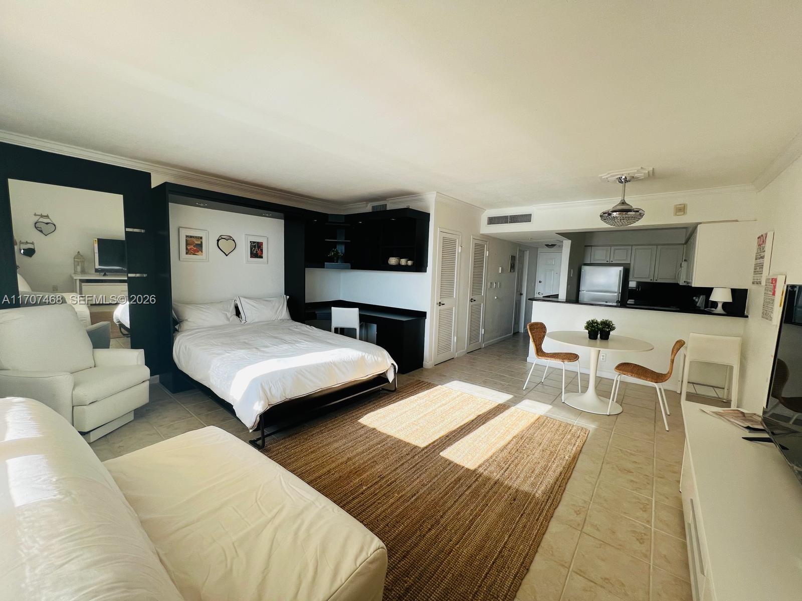 A studio apartment features a bed, a desk, a dining table, and a kitchen area — 2501 S Ocean Dr, Hollywood FL 33019, HOLLYWOOD, FL