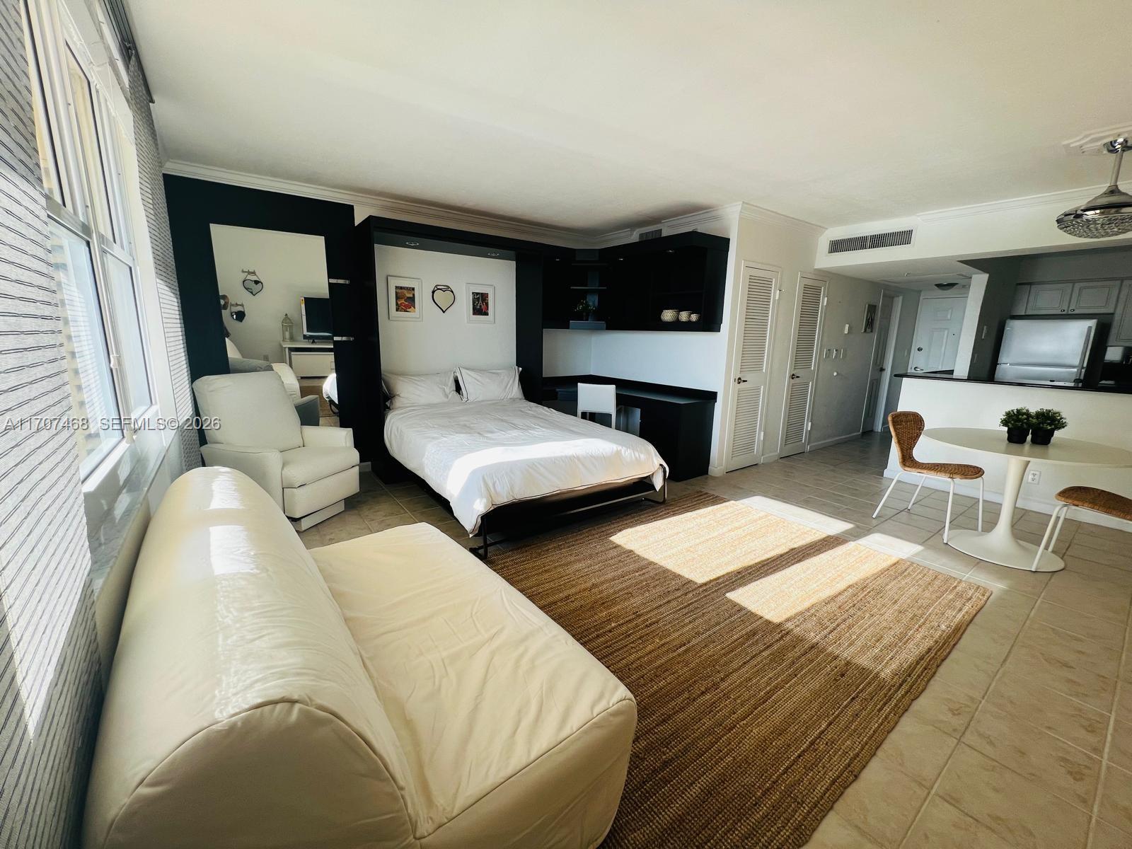 A studio apartment features a Murphy bed, a white sofa, and a small dining area — 2501 S Ocean Dr, Hollywood FL 33019, HOLLYWOOD, FL