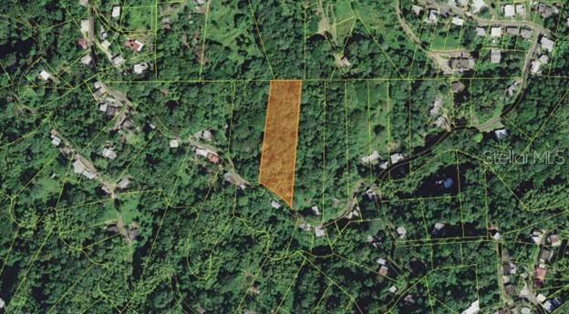 An aerial view shows a highlighted plot of land surrounded by trees and residential properties — PR-354 KM 6.4 MARINI COMMUNITY - QUEMADO WARD, MAYAGUEZ, PR