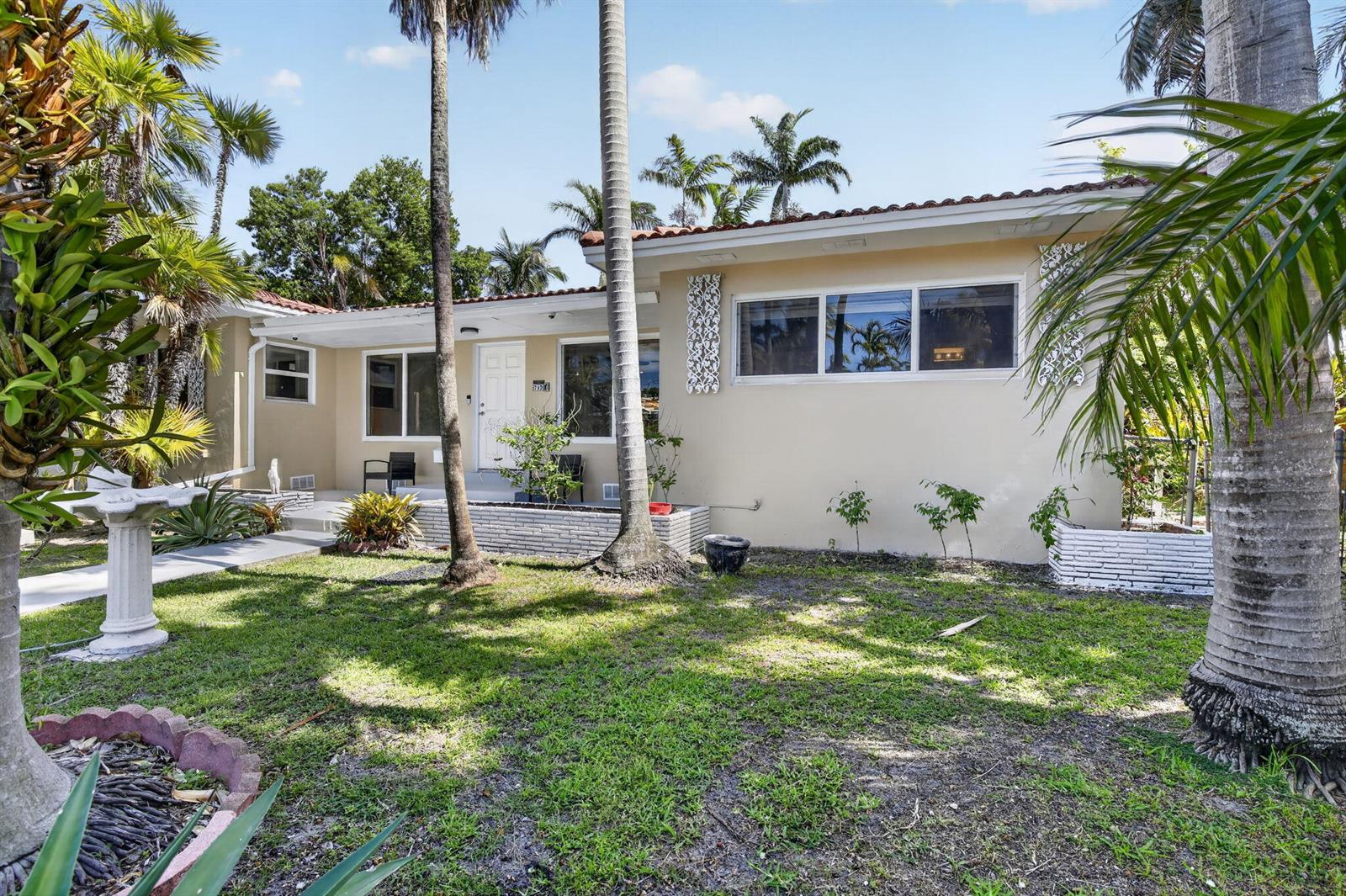 A single-story house with a beige exterior, palm trees, and a front yard — 742 Hollywood Boulevard, Hollywood FL 33019, HOLLYWOOD, FL