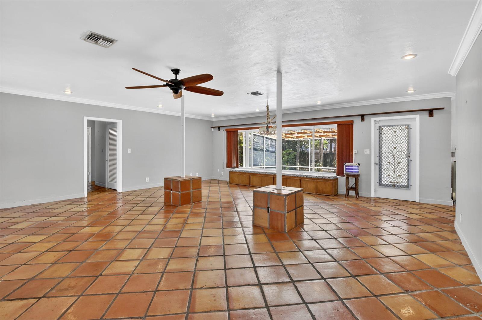 A spacious living room features terracotta tile flooring, two structural support columns, and a window seat — 742 Hollywood Boulevard, Hollywood FL 33019, HOLLYWOOD, FL