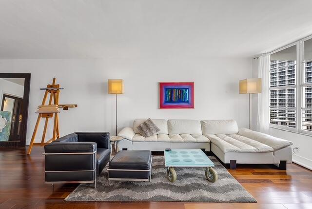 A living room features a white sectional sofa, a black leather chair, and an artist's easel — 2851 S Ocean Boulevard # C, Boca Raton FL 33432, BOCA RATON, FL