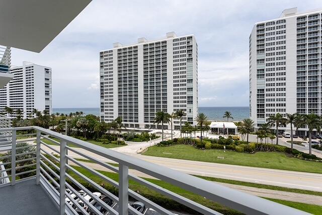 A balcony view overlooking a road, palm trees, and tall residential buildings near the ocean — 2851 S Ocean Boulevard # C, Boca Raton FL 33432, BOCA RATON, FL