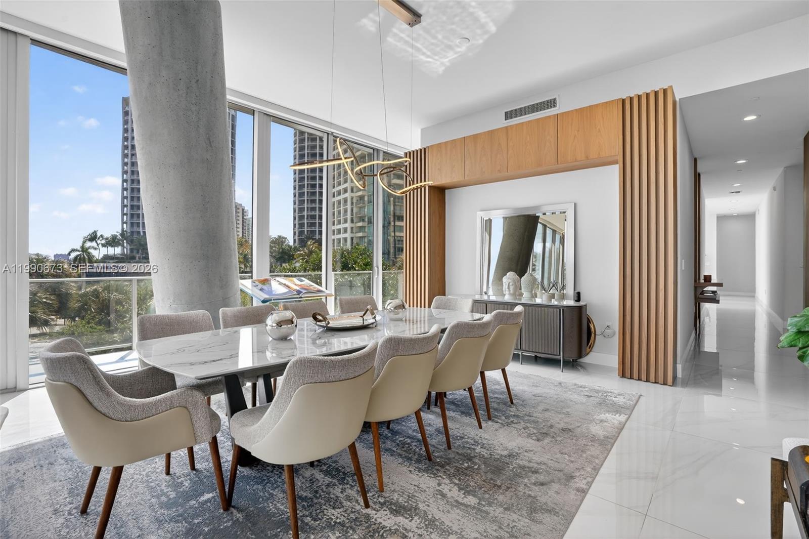 A modern dining room features a marble table, upholstered chairs, and floor-to-ceiling windows — 2675 S Bayshore Dr # 402S, Miami FL 33133, MIAMI, FL
