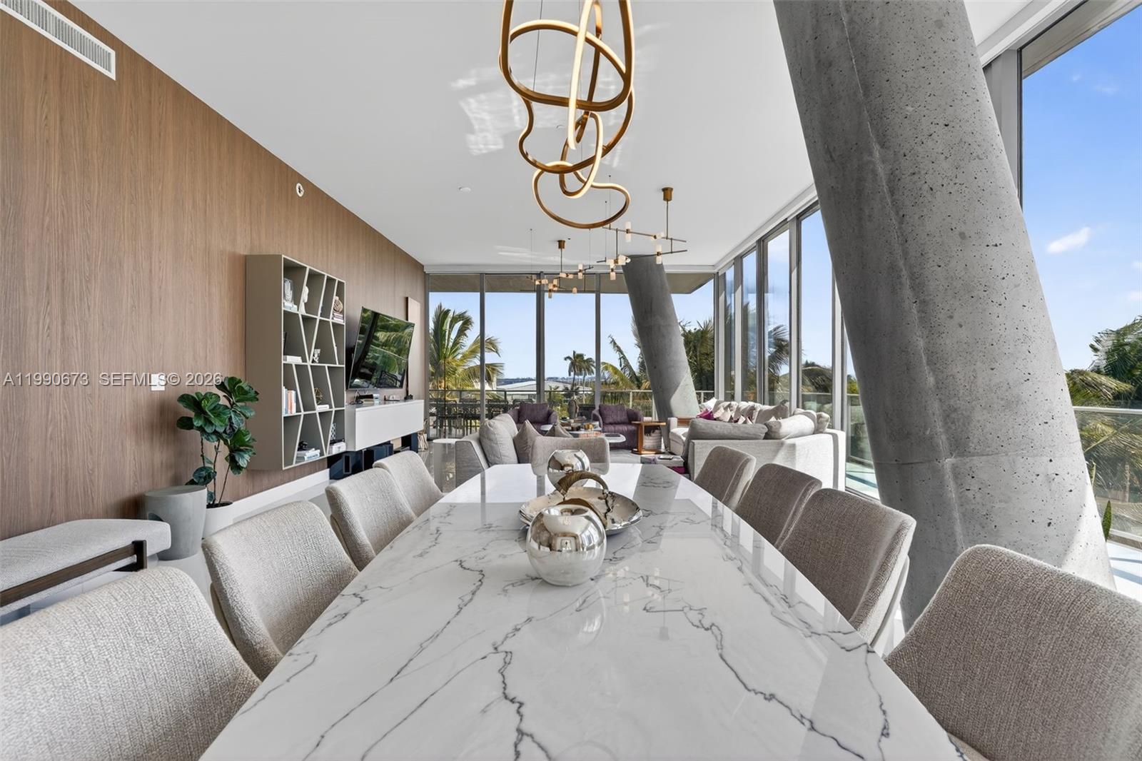 A dining room features a marble table, modern light fixtures, and floor-to-ceiling windows — 2675 S Bayshore Dr # 402S, Miami FL 33133, MIAMI, FL