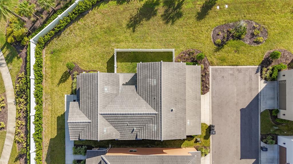 An aerial view shows a house with a gray shingled roof and a fenced backyard — 5414 LATCHES LANE UNIT 3A Garden, LAKEWOOD RANCH, FL