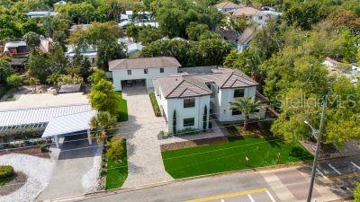 An aerial view shows a two-story house with a paved driveway and a green lawn — 1850 WEBBER STREET, SARASOTA, FL