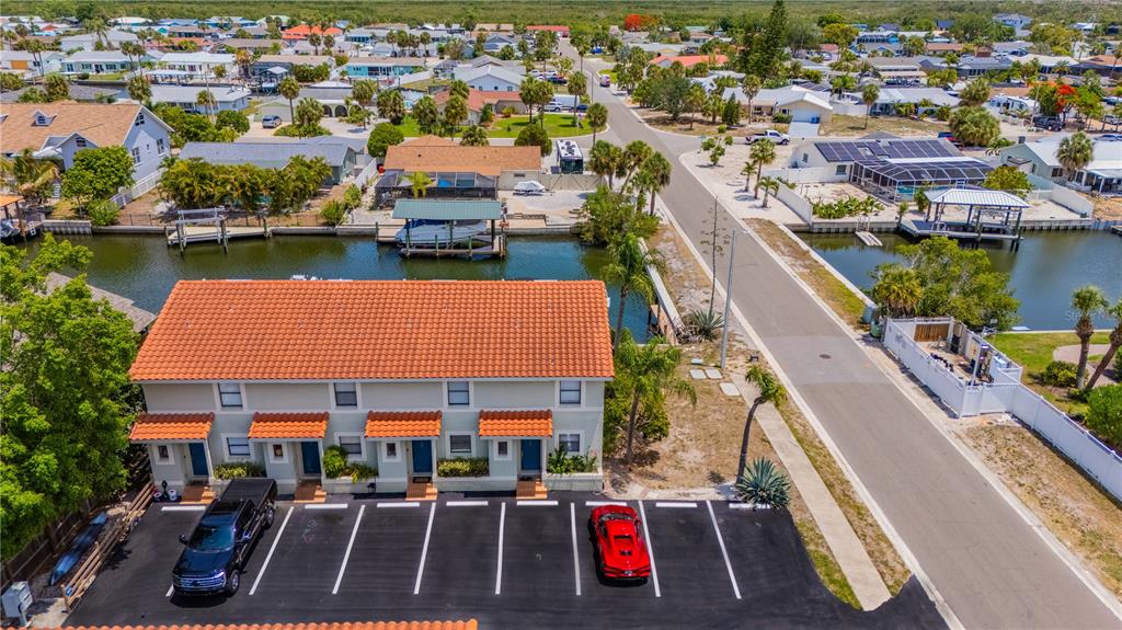An aerial view shows a multi-unit building with a tiled roof and a parking lot — 6506 ABACO DRIVE UNIT 104, APOLLO BEACH, FL