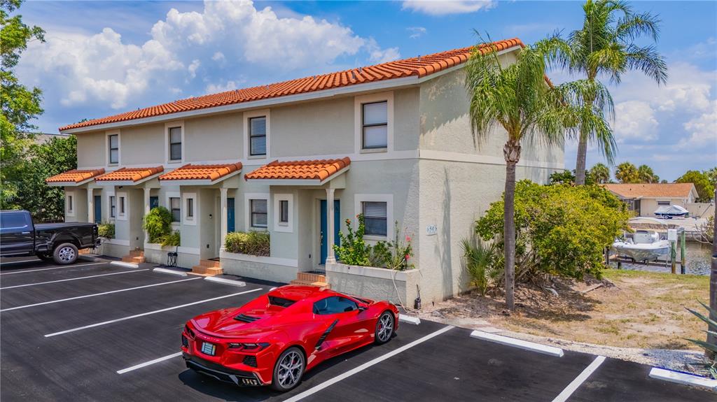 A red sports car is parked in front of a two-story townhouse with a tiled roof — 6506 ABACO DRIVE UNIT 104, APOLLO BEACH, FL