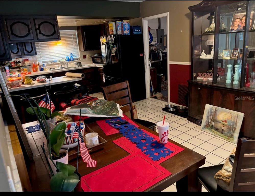 A dining area with a wooden table and a hutch sits adjacent to a kitchen — 12728 83RD AVENUE, SEMINOLE, FL