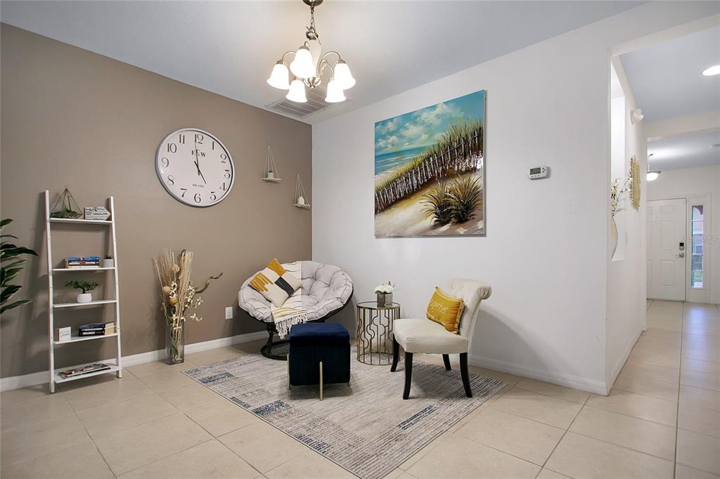A seating area features a round chair, an accent chair, a rug, and wall decor — 1338 YORKSHIRE COURT, DAVENPORT, FL