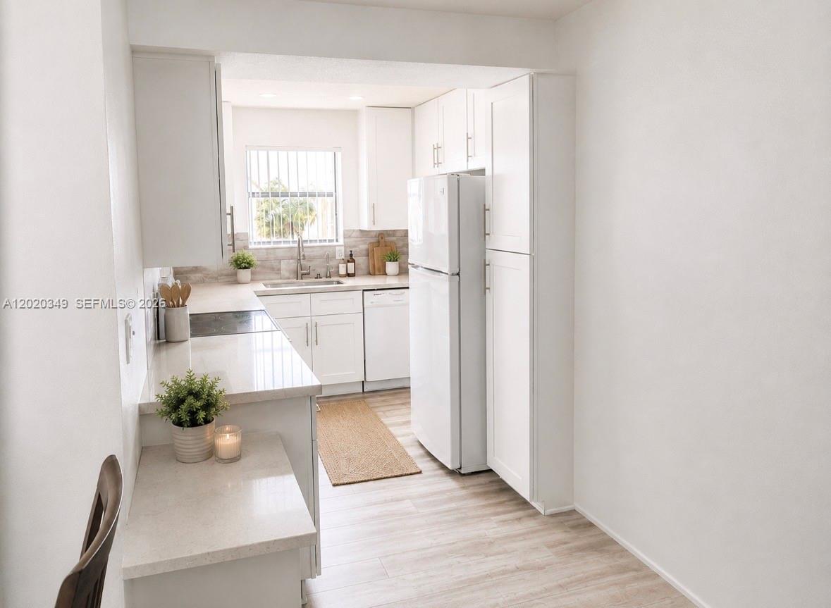 A bright kitchen features white cabinets, light countertops, and stainless steel appliances — 10440 SW 156th Ct # 726, Miami FL 33196, MIAMI, FL