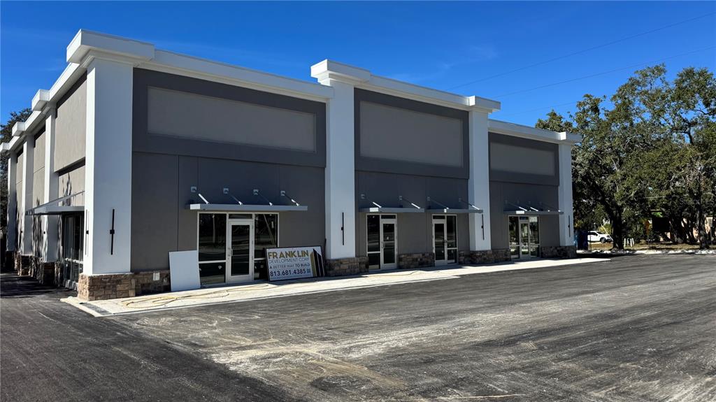 A newly constructed commercial building with three storefront entrances and a paved parking lot — 11210 N 30TH STREET, TAMPA, FL