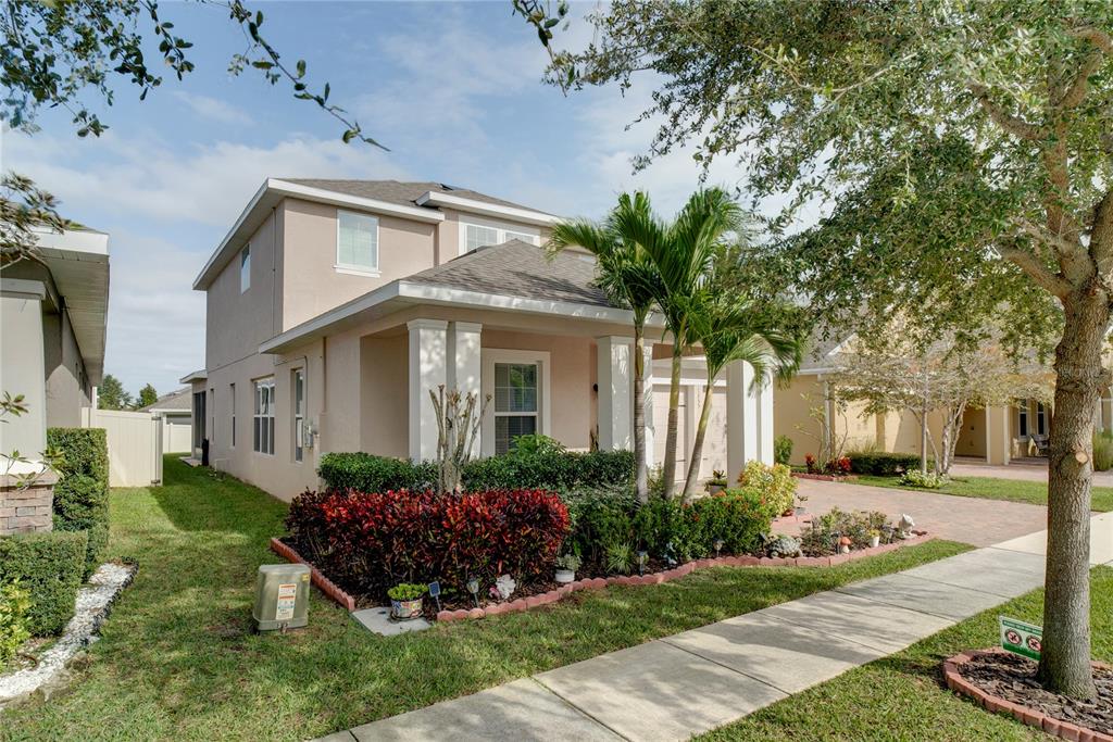 A two-story suburban house with a covered porch, palm trees, and a landscaped front yard — 15755 SWEET LIMETTA DRIVE, WINTER GARDEN, FL