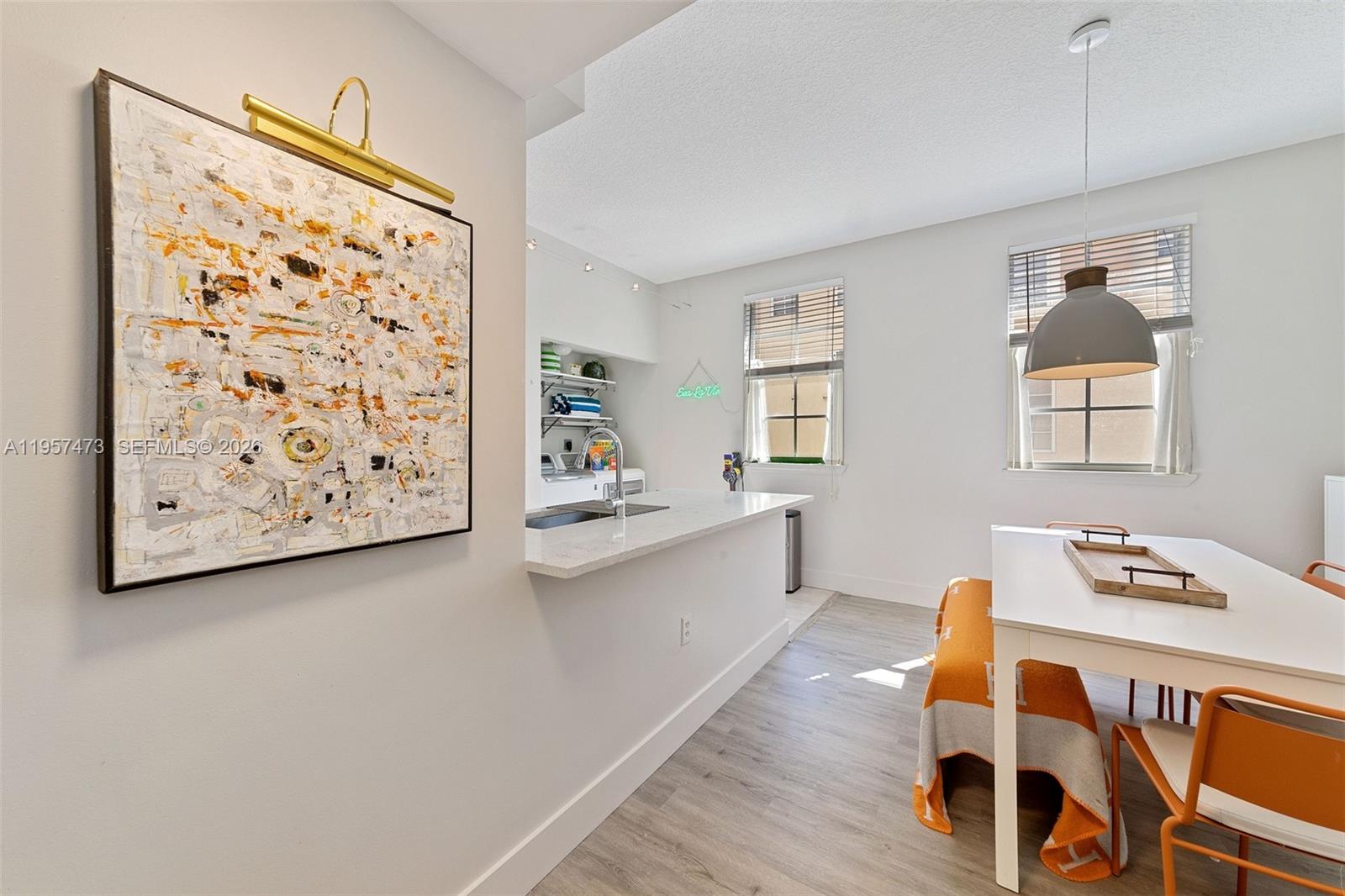 A kitchen with a breakfast bar, dining area, and light wood-look flooring — 2067 S Ocean Dr, Hallandale Beach FL 33009, HALLANDALE BEACH, FL