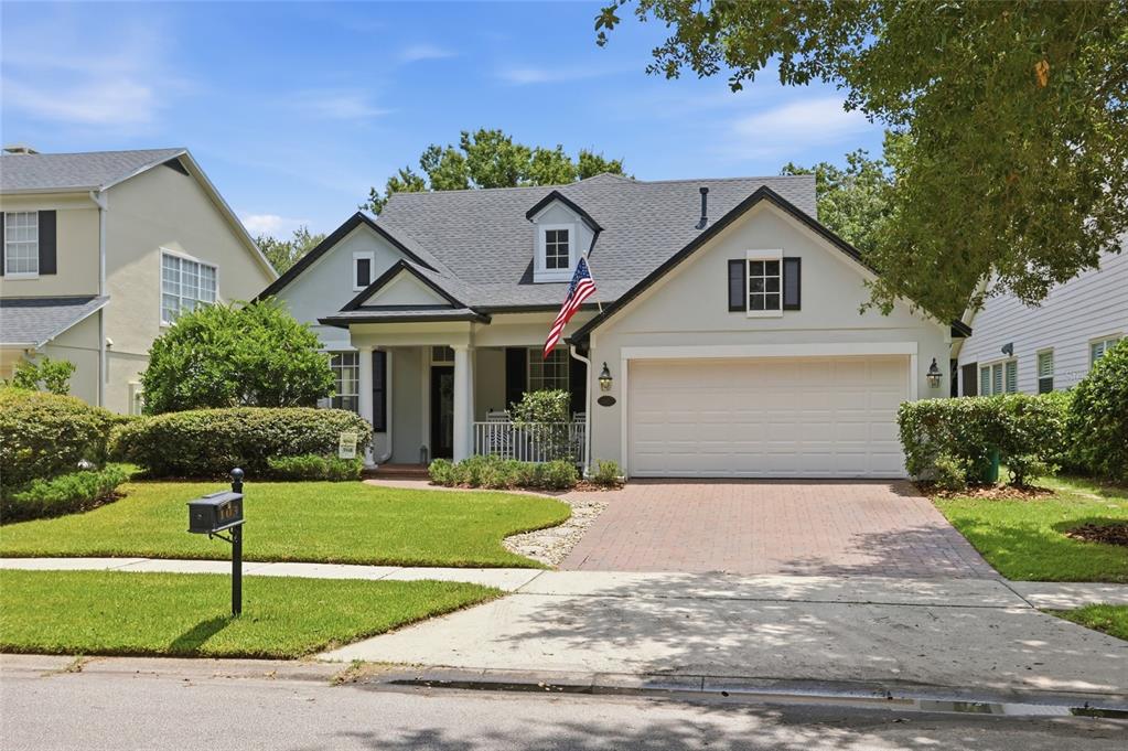 A single-story house with a brick driveway, a front porch, and an American flag — 103 ASTERBROOKE DRIVE, DELAND, FL