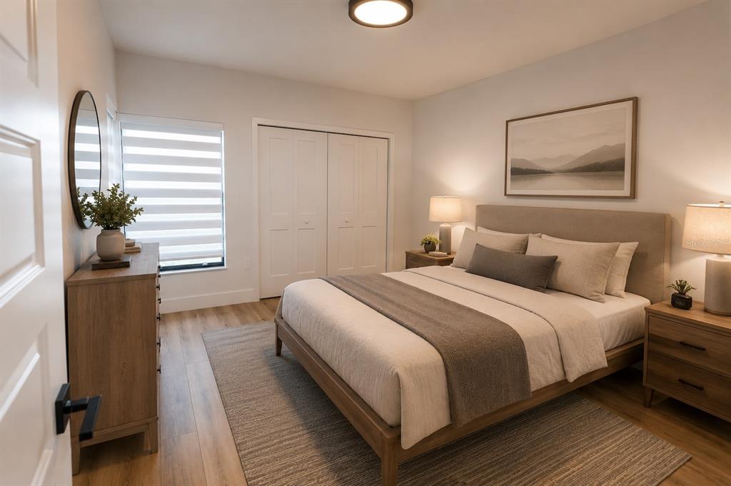 A bedroom features a bed with a neutral-toned headboard, wooden furniture, and a large area rug — 4704 CHEVY PLACE UNIT 180, ORLANDO, FL