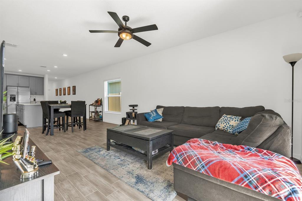 A living room with a gray sectional sofa, coffee table, and an adjacent dining area — 555 JETT LANE, DAVENPORT, FL