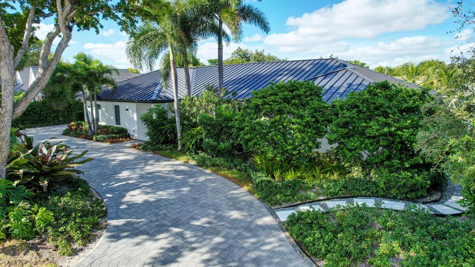 A paved driveway leads to a white house with a dark metal roof and landscaping — 41 S Compass Drive, Fort Lauderdale FL 33308, FORT LAUDERDALE, FL