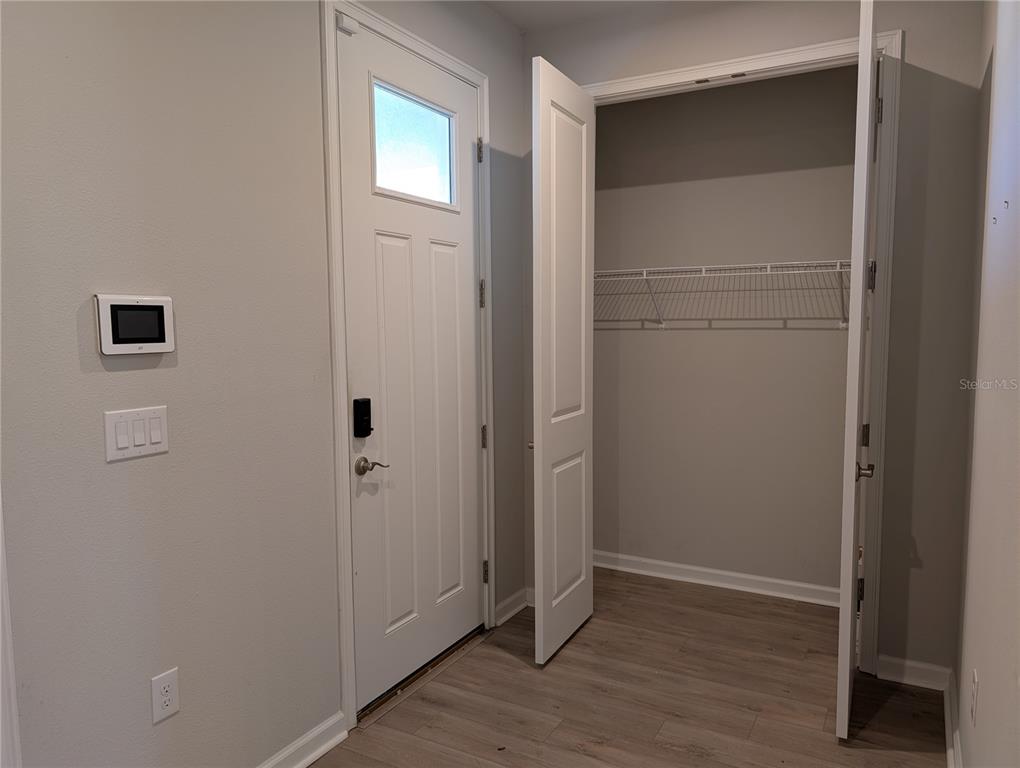 A white door with a glass pane stands next to an open closet with shelving — 3794 MAXWELL PARK DRIVE, SUN CITY CENTER, FL