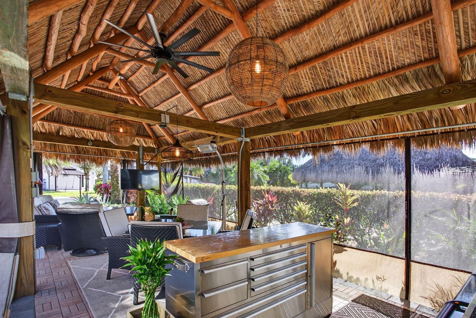 An outdoor covered patio with a thatched roof, ceiling fan, stainless steel island, and seating — 6 S Cortez Drive # 6, Margate FL 33068, MARGATE, FL