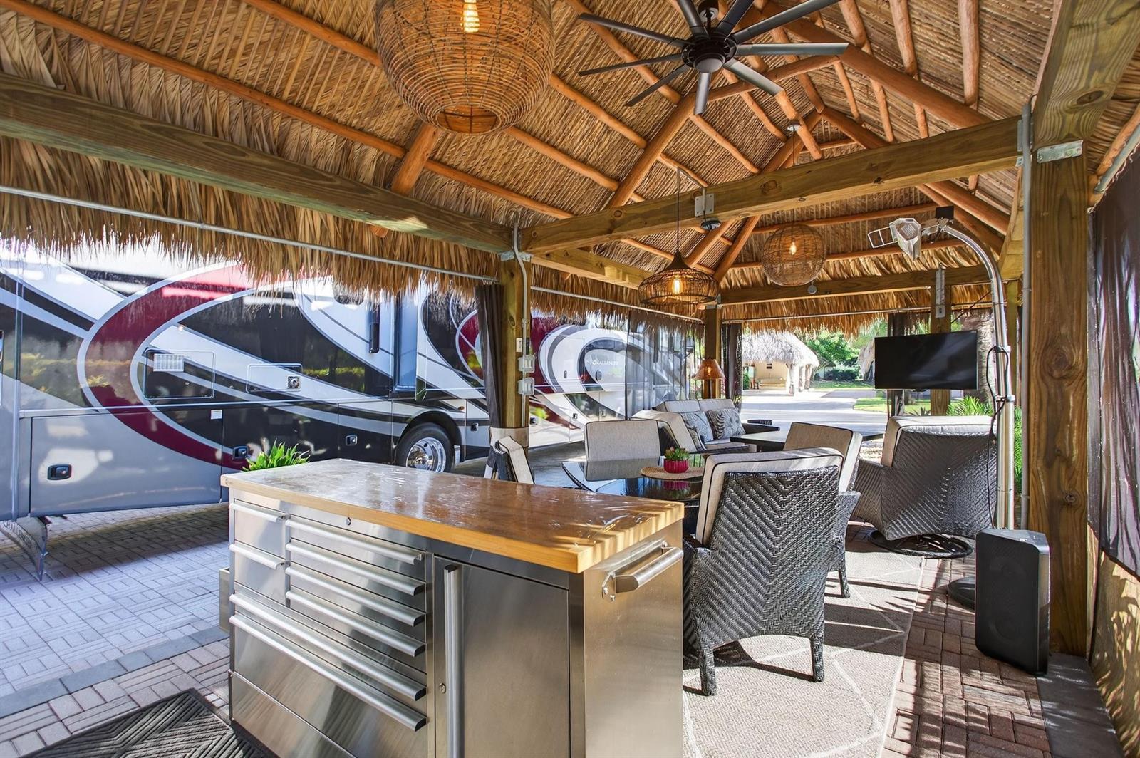 An outdoor living space with a thatched roof, dining furniture, and a stainless steel island — 6 S Cortez Drive # 6, Margate FL 33068, MARGATE, FL