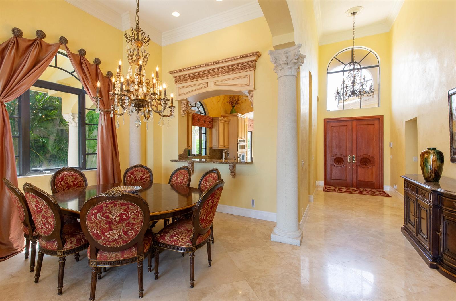 A dining room with a chandelier, ornate chairs, and a pass-through to the kitchen — 529 Pelican Way, Delray Beach FL 33483, DELRAY BEACH, FL