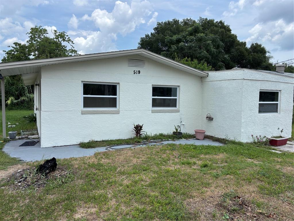 A single-story white stucco house with a carport and three windows on the exterior wall — 519 KATHERINE AVENUE, ORLANDO, FL