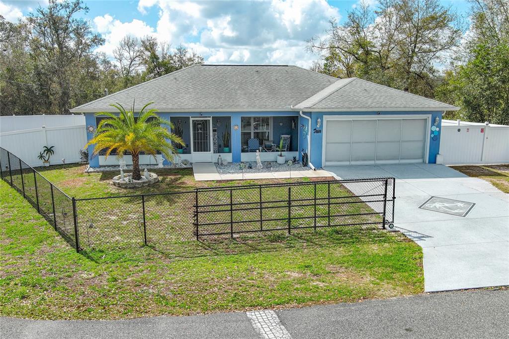 A blue single-story house with a concrete driveway, a chain-link fence, and a white mailbox — 9430 SE 158TH STREET, SUMMERFIELD, FL