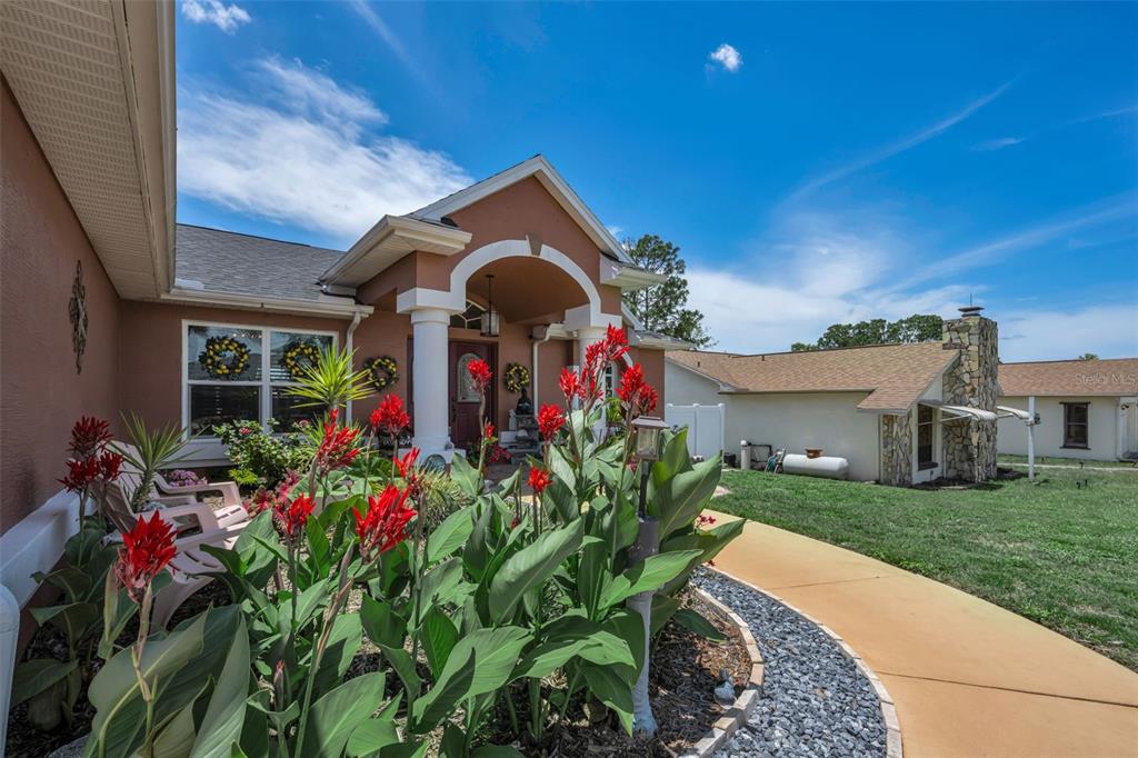 A screened-in patio features paver flooring, outdoor furniture, and a view of the backyard — 11210 AUBURNDALE STREET, SPRING HILL, FL