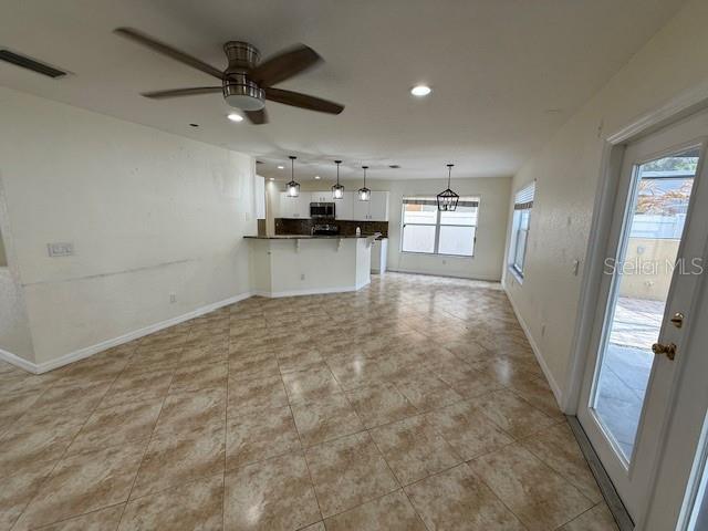 An open-concept kitchen and living area features tile flooring, a ceiling fan, and pendant lighting — 11722 CREST CREEK DRIVE, RIVERVIEW, FL