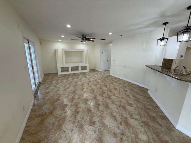 An open-concept living area features tile flooring, a built-in media center, and a kitchen island — 11722 CREST CREEK DRIVE, RIVERVIEW, FL