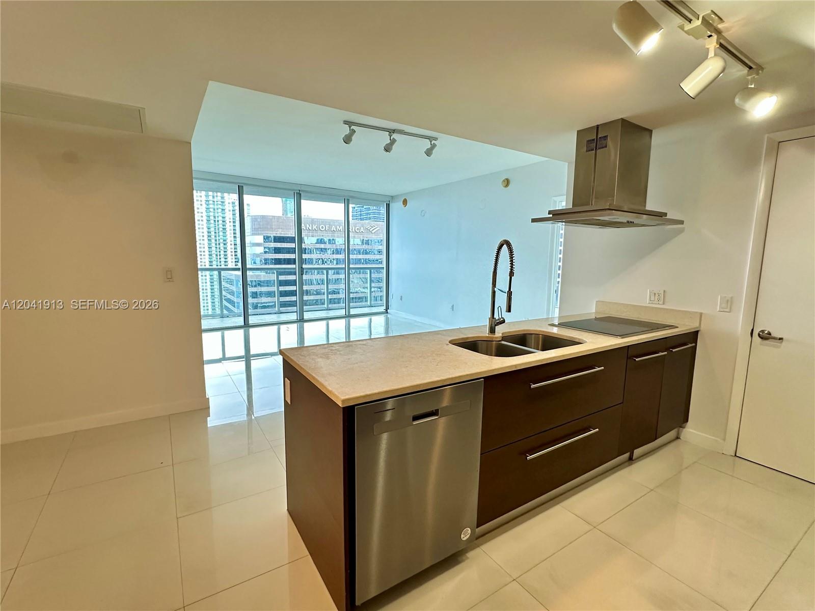 A modern kitchen features dark wood cabinets, stainless steel appliances, and floor-to-ceiling windows — 495 Brickell Ave # 4011, Miami FL 33131, MIAMI, FL
