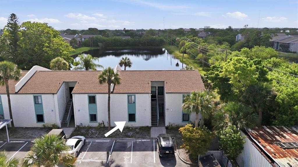 An aerial view shows a two-story apartment building with a parking lot and a pond — 11409 8TH STREET N UNIT 1509, ST PETERSBURG, FL
