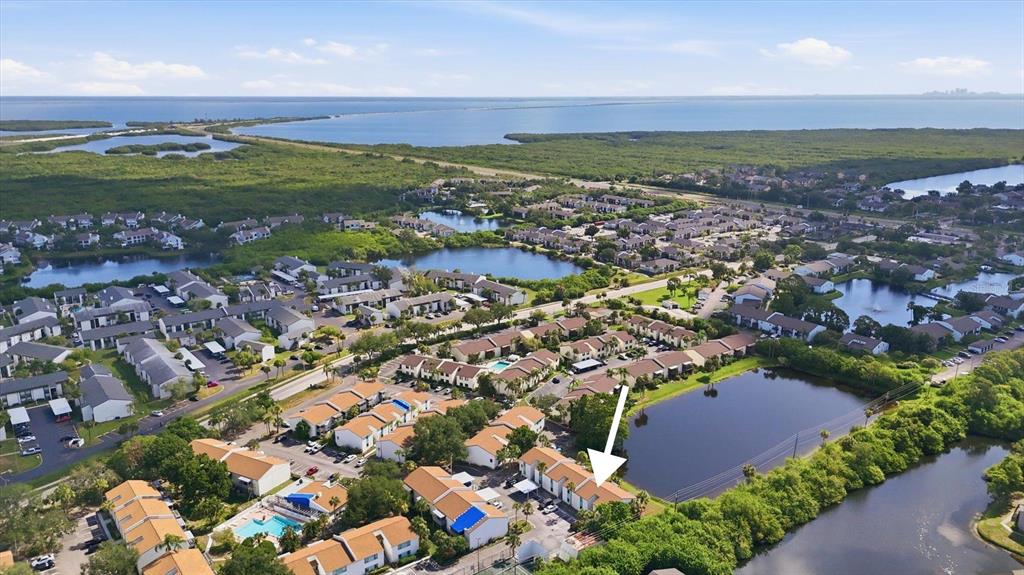 An aerial view shows a residential complex with multiple buildings, ponds, and surrounding greenery — 11409 8TH STREET N UNIT 1509, ST PETERSBURG, FL