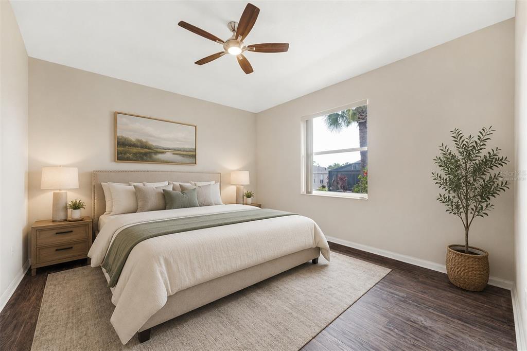 A bedroom features a king bed, two nightstands, a ceiling fan, and a potted tree — 1149 EMERALD DUNES DRIVE, SUN CITY CENTER, FL