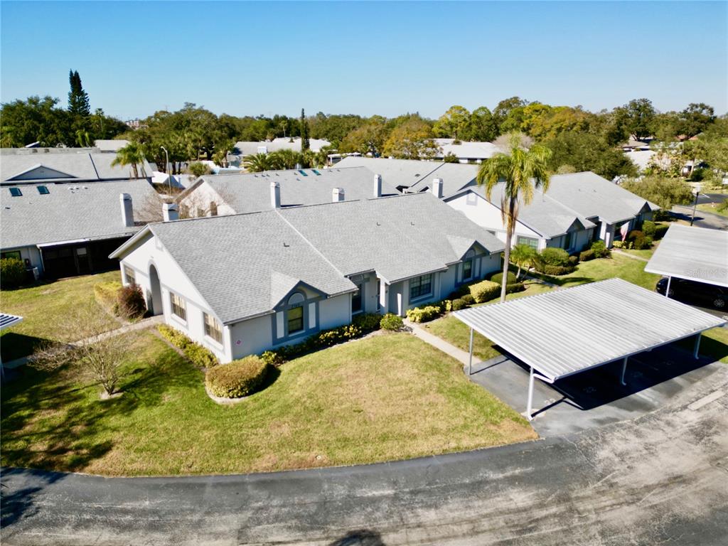 An aerial view shows a single-story residential building with a gray roof and carport — 2749 COUNTRYSIDE BOULEVARD UNIT 22, CLEARWATER, FL