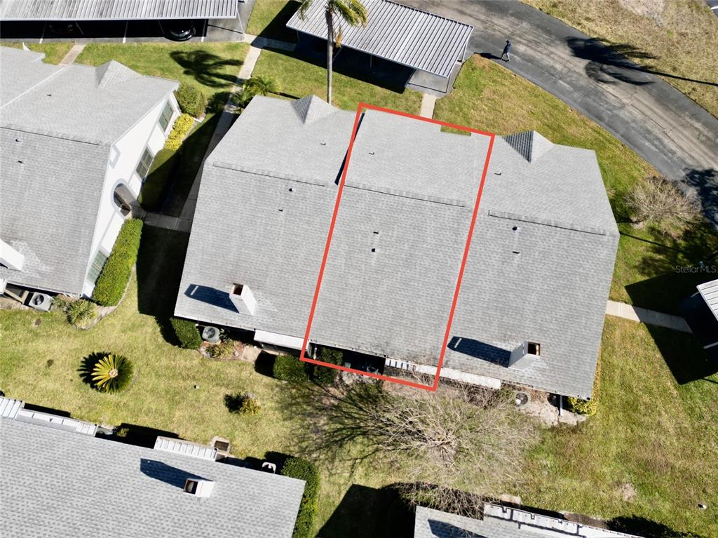 An aerial view shows the grey shingled roof of a townhouse unit outlined in red — 2749 COUNTRYSIDE BOULEVARD UNIT 22, CLEARWATER, FL