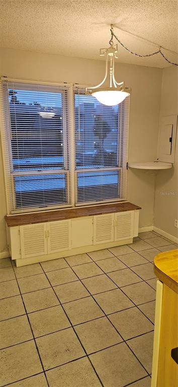 A dining area features a window with blinds, a built-in cabinet, and a hanging light fixture — 2617 COVE CAY DRIVE UNIT 311, CLEARWATER, FL