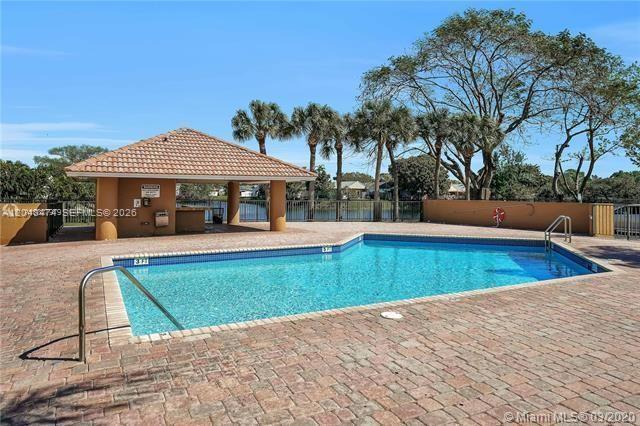 A swimming pool with a tiled deck sits in front of a covered outdoor pavilion — 7401 SW 152nd Ave # 1, Miami FL 33193, MIAMI, FL