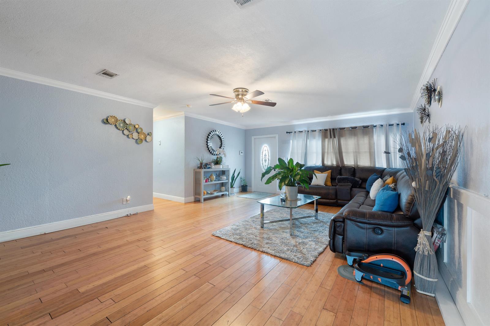 A living room features hardwood floors, a dark leather sectional, and a glass coffee table — 808 Wright Drive, Lake Worth FL 33461, LAKE WORTH, FL