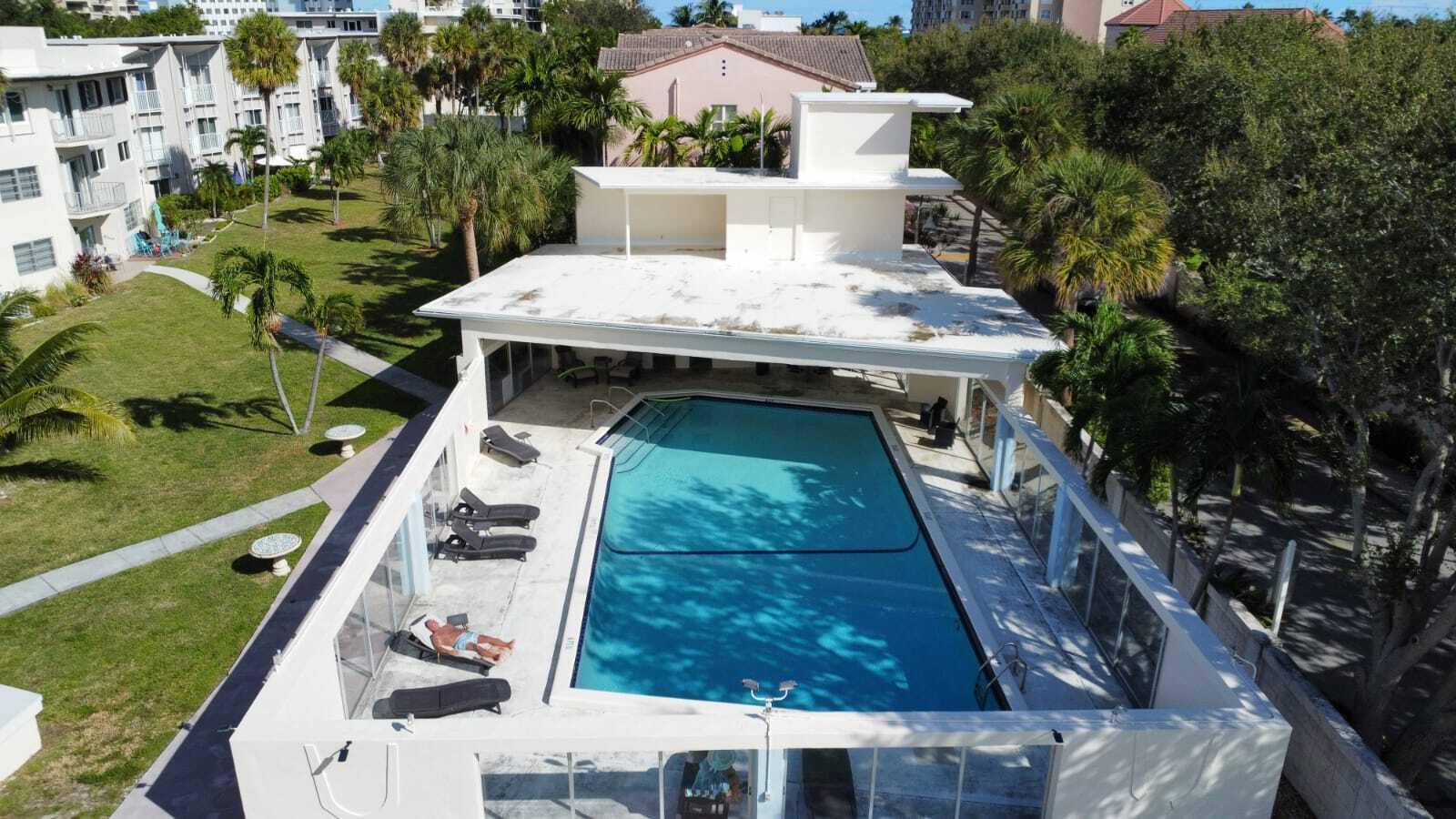An aerial view of an outdoor swimming pool surrounded by lounge chairs and a patio — 1967 S Ocean Boulevard # 221d, Pompano Beach FL 33062, POMPANO BEACH, FL