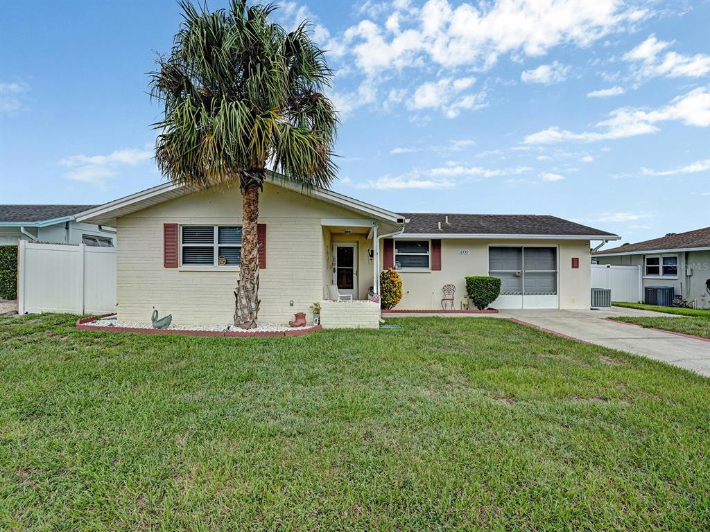 A single-story house with a palm tree in the front yard and a garage — 6732 WILLIAM TELL DRIVE, NEW PORT RICHEY, FL