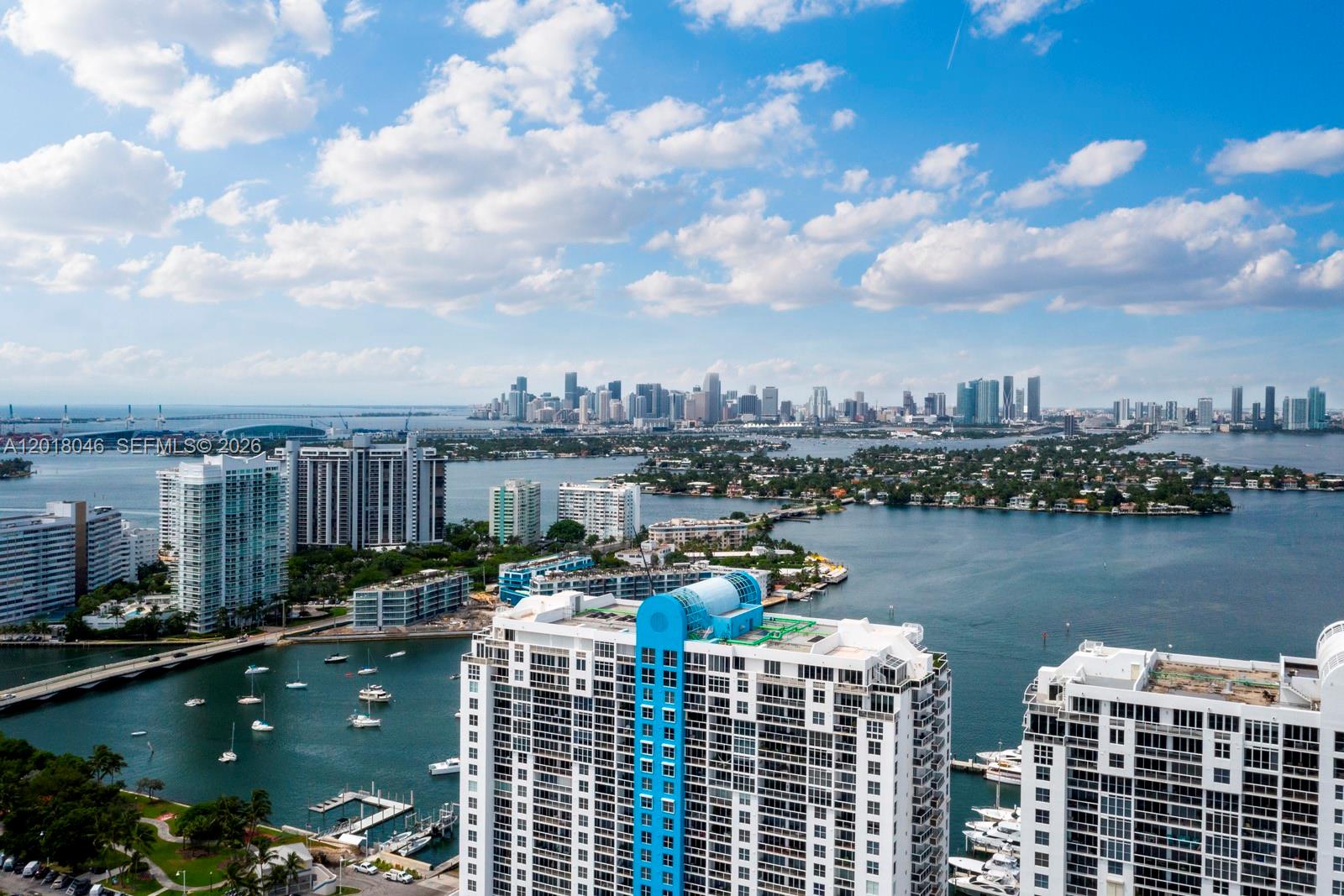An aerial view shows high-rise buildings, a marina, and the Miami skyline across the water — 1800 Sunset Harbour Dr # 1601, Miami Beach FL 33139, MIAMI BEACH, FL