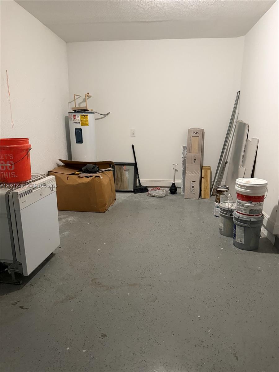 This utility room features a water heater, a dishwasher, and various construction materials on concrete — 1247 NE 23rd Ave, Pompano Beach FL 33062, POMPANO BEACH, FL