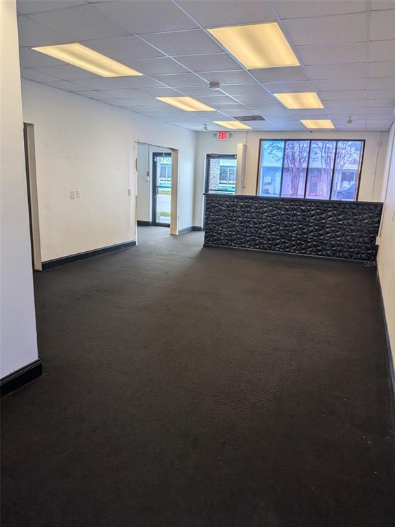 An interior view of a commercial space featuring dark carpeting, white walls, and a reception desk — 5630 PARK BOULEVARD N UNIT A & B, PINELLAS PARK, FL
